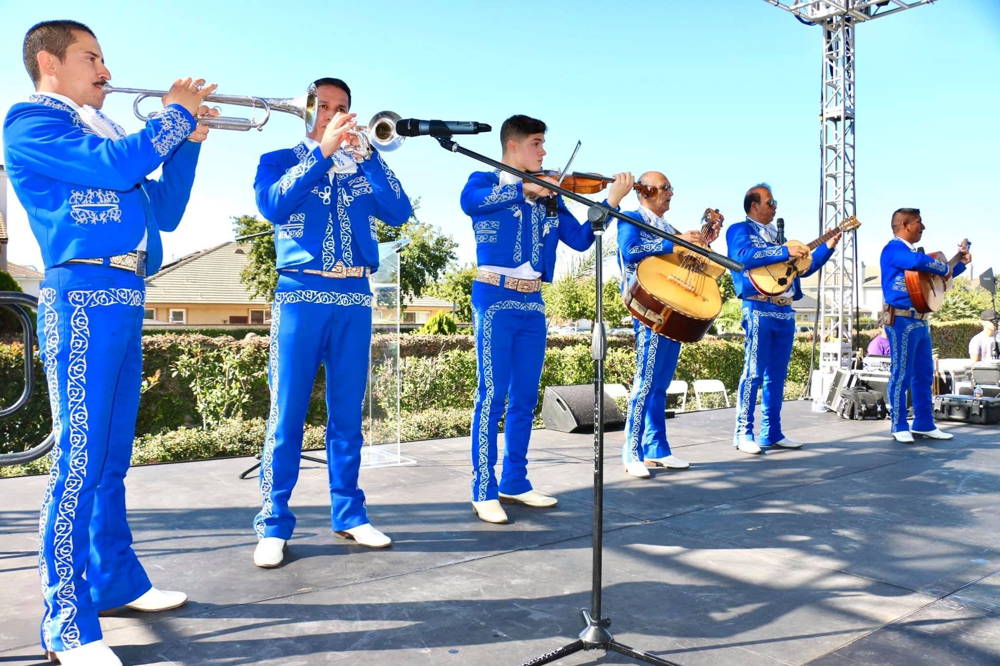 Mariachi Real De Oxnard performing outdoors in blue suits